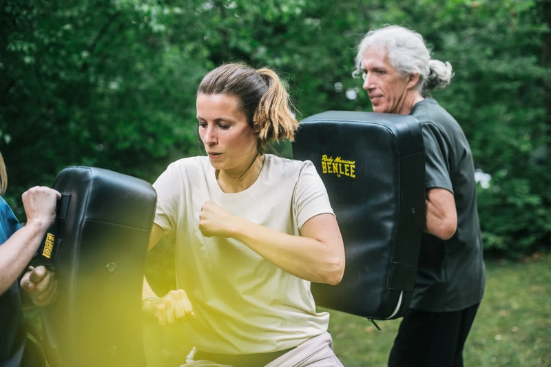 Frau schl&auml;gt gegen Box Sack in einer Gruppen&uuml;bung