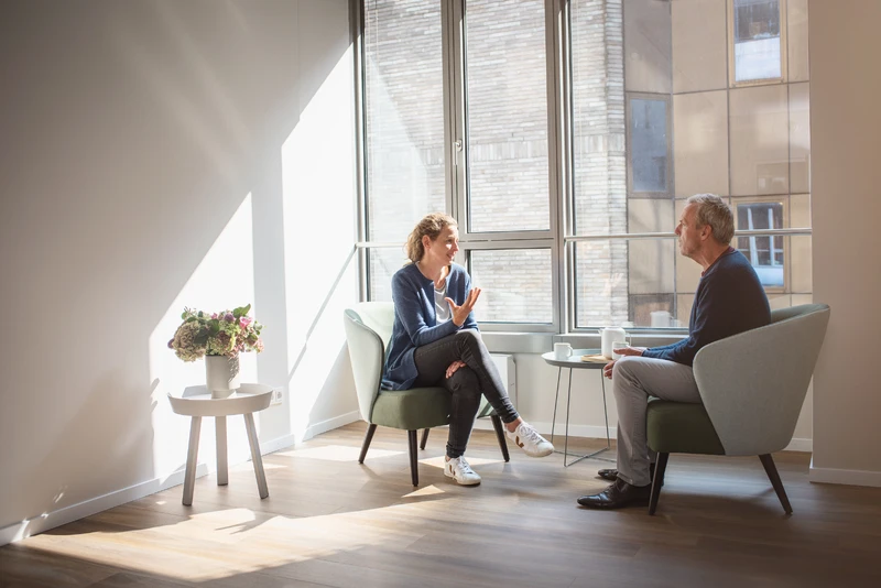 Therapeutin spricht mit Patientin und nutzt holzblock steine.